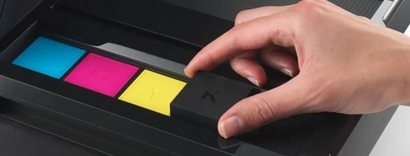 Hand inserting cyan, magenta, yellow and black toner into a copier